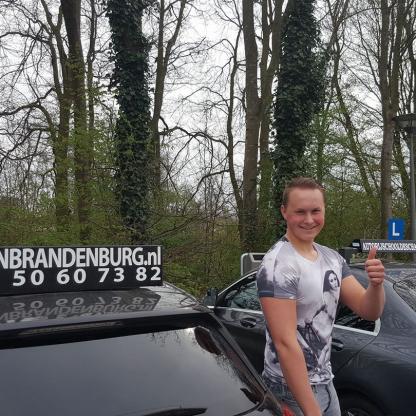 Geslaagde leerling bij de lesauto van Autorijschool van Brandenburg
